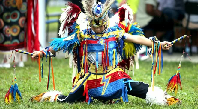 Community members and visitors gather at Neyaashiinigmiing powwow